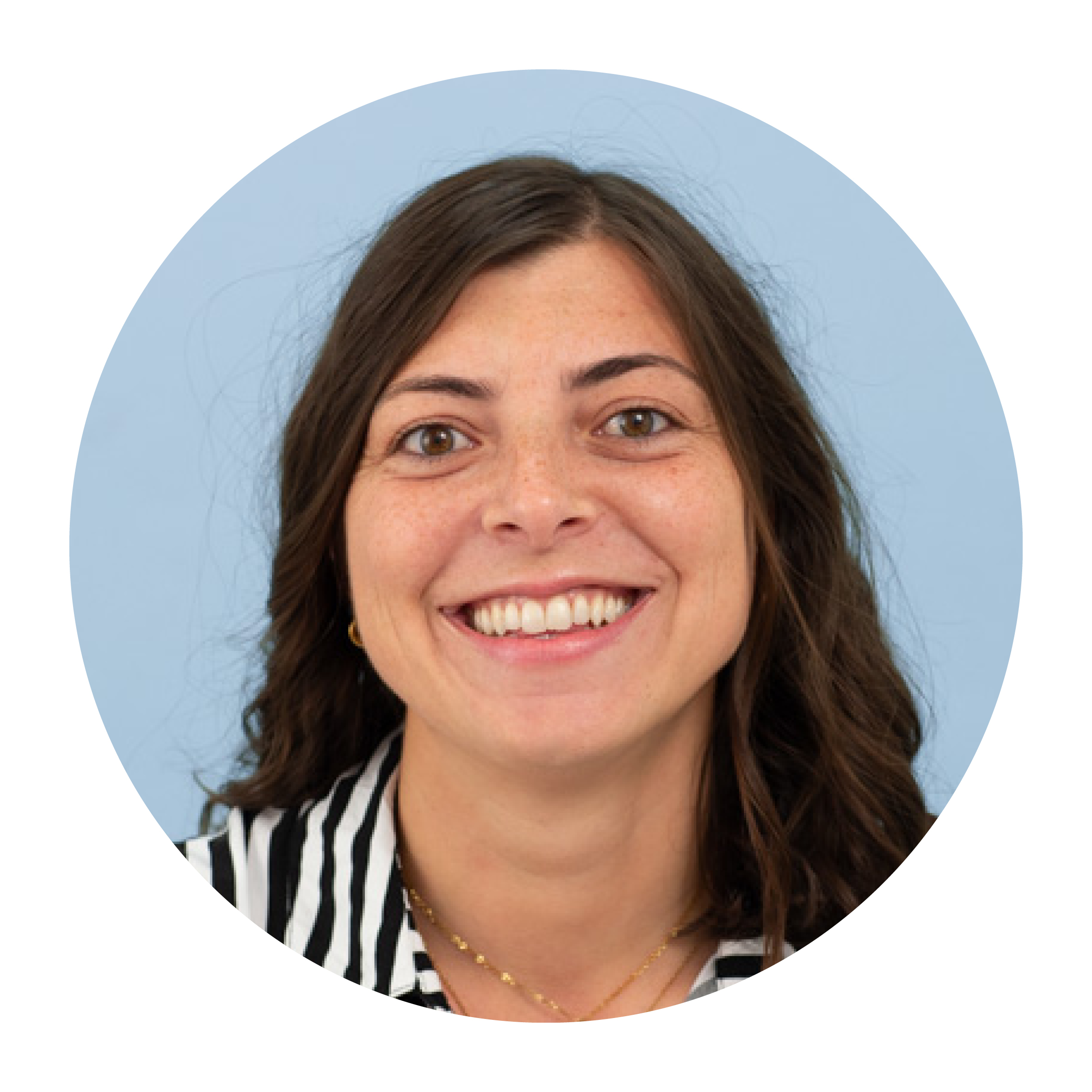 Portrait of Delia Onorini, a white woman with long brown hair worn loose, wearing a black-and-white striped top and smiling broadly.